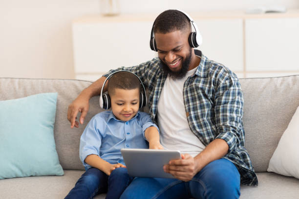 istock African Dad And Son Using Tablet Wearing Headphones At Home 1309055807