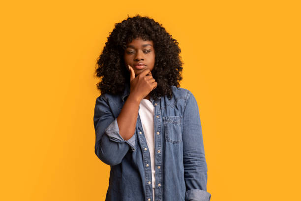 istock Confused young black woman thinking and looking aside 1309056172