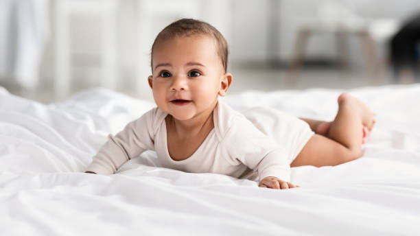 istock Cute little African American infant lying on white bed 1309056206