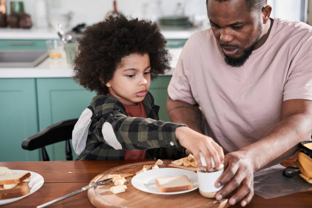 istock Boy sitting at the table with his father while preparing breakfast 1309057296