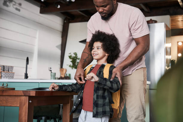 istock Father helping to his little smiling son putting on his backpack 1309057297