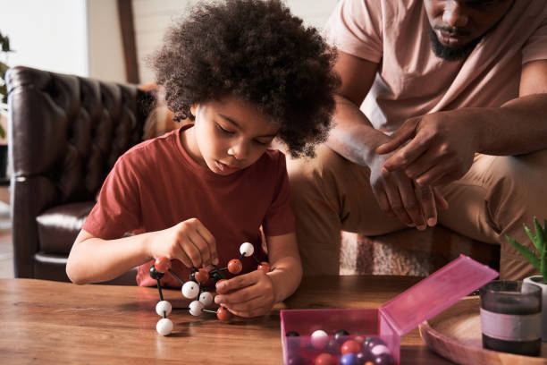 istock Boy playing at educational game with his father while spending weekend at home 1309057349