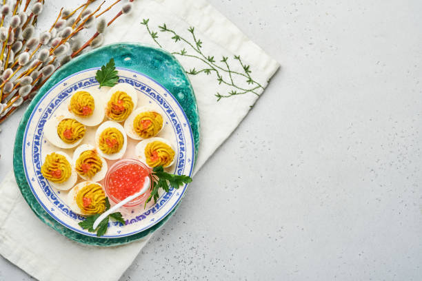 istock Stuffed eggs with red caviar and paprika on plate for appetizer easter table, top view, copy space. Traditional dish for Happy Easter holiday. 1309059969
