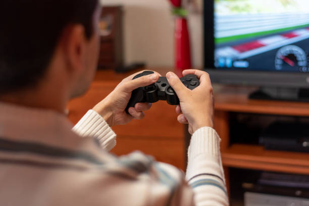 istock Man playing with game console at home. Concept of playing with the console 1309060080