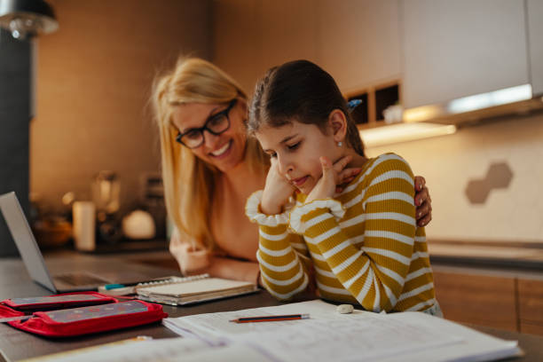 istock Single mother helping her daughter about education at home 1309061176