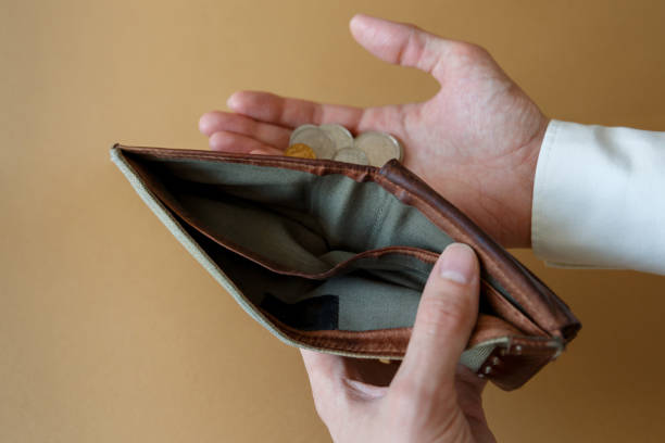 istock Empty wallet in the hands of a man on a plain background 1309061635
