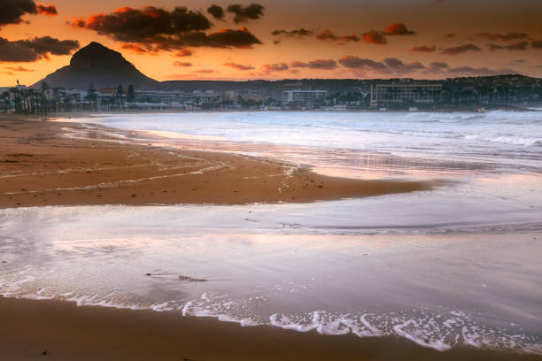 Setting sun casting some beautiful light over the Mediterranean Sea in Javea, Alicante, Spain.