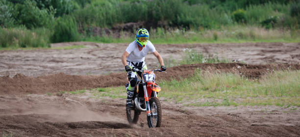 un pilote de motocross en action, pratiquant sur un parcours de sable - motor racing track motorcycle sports race competition photos et images de collection