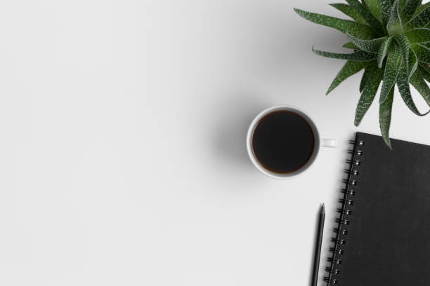 istock Workspace accessories, cup of coffee and a succulent plant on a white table.  Flat lay with blank copy space. 1309064966