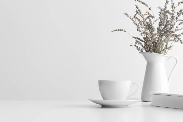 istock White book, cup of a coffee and a lavender in a vase on a white table. Flat lay with blank copy space. 1309065099