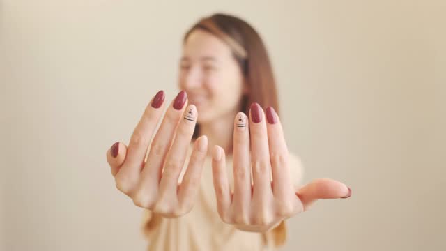 Smiling woman is showing her hands with stylish manicure.