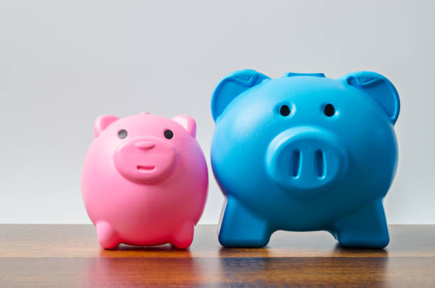istock Pink and blue piggy bank on table background 1309067905