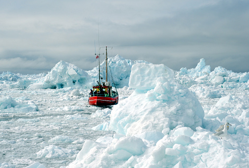 Fishing boats are breaking through icebergs in the Arctic Ocean.