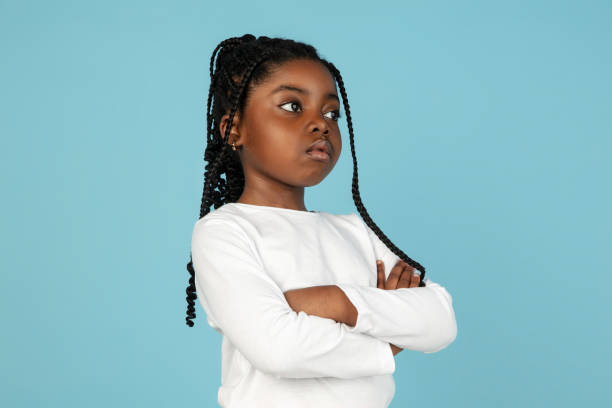 schöne afrikanische kleine mädchen porträt isoliert auf blauem studio hintergrund mit copyspace - child bizarre little girls humor stock-fotos und bilder