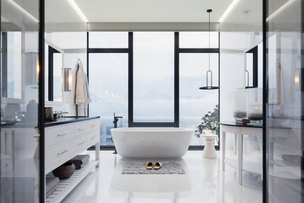 Luxury Bathroom Interior With hot tub And Beautiful Sea View Interior of a contemporary luxury white bathroom with washstand and bathtub. hotel window view stock pictures, royalty-free photos & images
