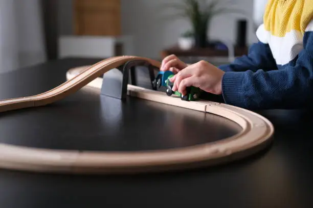Photo of Cute little boy playing with wooden train
