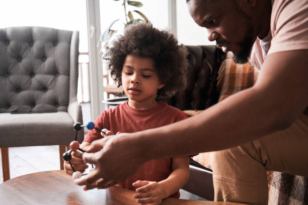 istock Man playing with his son while sitting at the sofa at home 1309078239