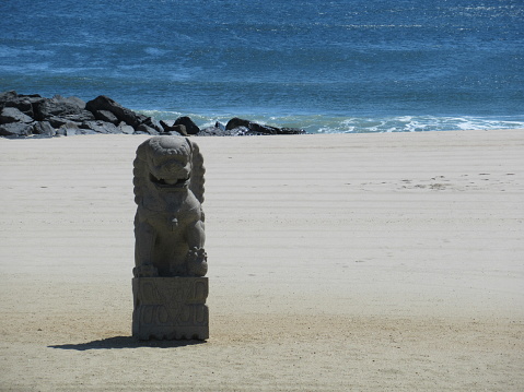Chinese lion statue on sandy beach