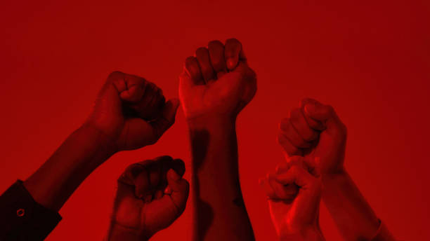 istock Fists on raised hands of multiracial people 1309081821