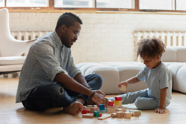 istock Happy african father and preschool son playing games developing mind 1309082399