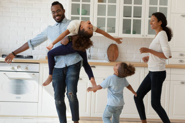 istock Cheering african couple with two children having party at kitchen 1309082451