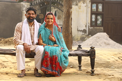 Indian happy rural couple in village looking at camera with a smiling face.