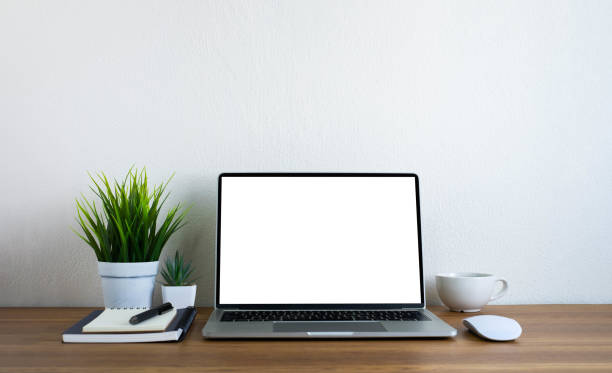 istock Front view of open laptop computer notebook with blank monitor white screen display on work table desk. Workspace office modern business online technology. Flat lay with blank copy space. 1309083637