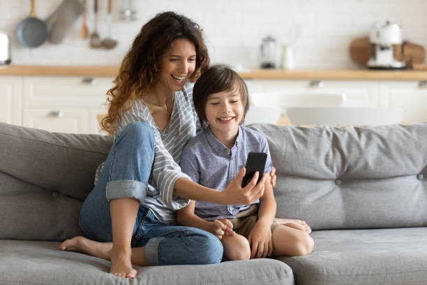 istock Smiling young mother and little son using phone together 1309085623