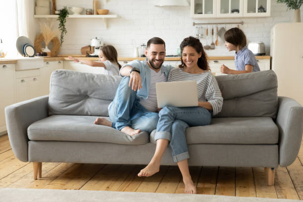 istock Happy parents using laptop while kids playing funny game 1309085651
