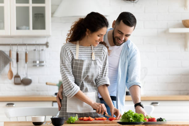 istock Happy loving couple preparing dinner in kitchen together, hugging 1309085656