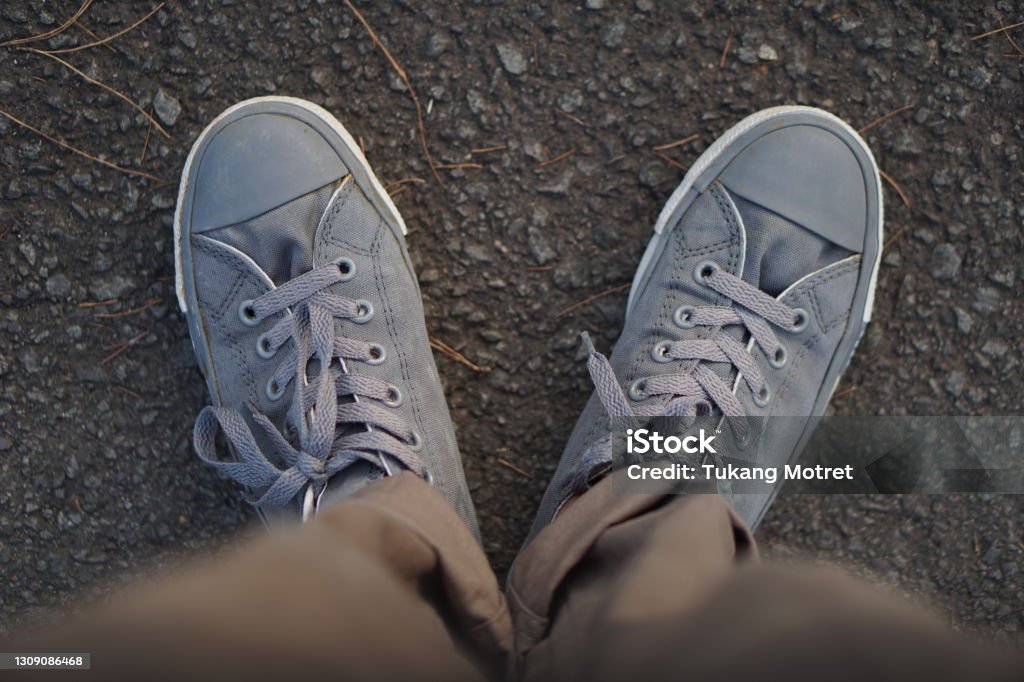 the direction of the foot step shoes are a witness to where we go, to the good or bad road Adult Stock Photo