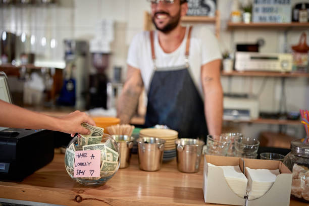 satisfied customer leaving tip in a bowl with a positive message on a sticker. money, tip, satisfied, positive message satisfied customer in coffee shop leaving tip in a bowl with a positive message on a sticker. money, tip, satisfied, positive message leaving a tip stock pictures, royalty-free photos & images
