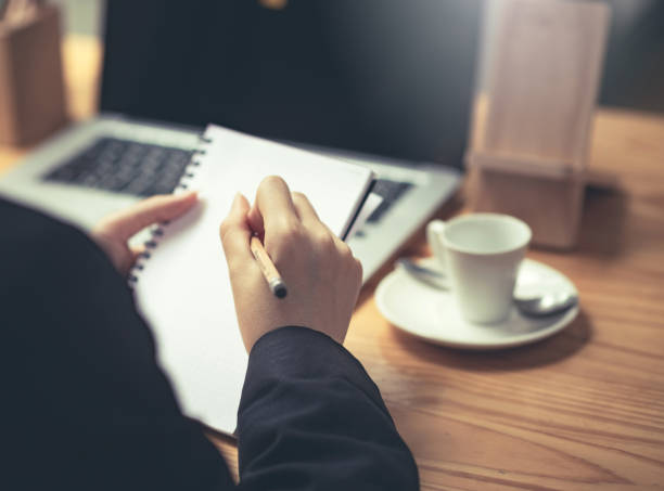 istock Close up. Woman taking notes on desk at office. 1309095068