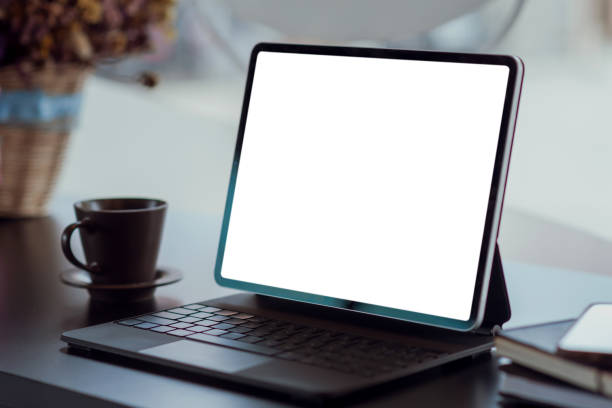 istock Mock up. blank screen digital tablet with office supplies on black wooden table. 1309095100