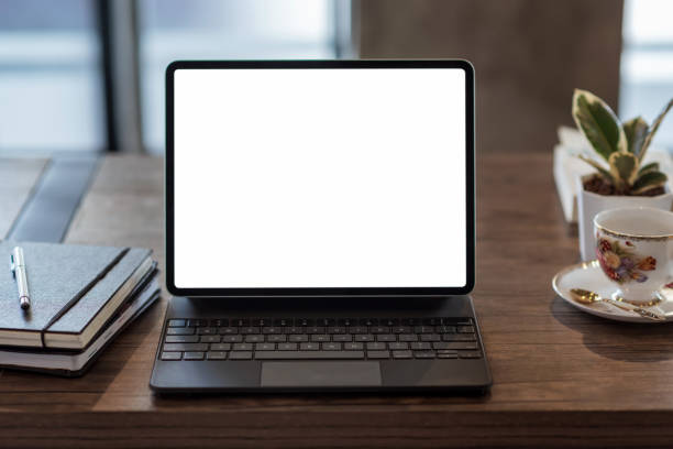 istock Mock up. blank screen digital tablet with office supplies on black wooden table. 1309095155