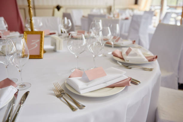 빈 게스트 카드, 분홍색과 흰색 서바이엣과 테이블에 칼붙이 접시가 있는 테이블 세트, 복사 공간. 결혼식 피로연에서 장소 설정. 레스토랑에서 웨딩 연회를 위해 제공되는 테이블 - wedding champagne table wedding reception 뉴스 사진 이미지