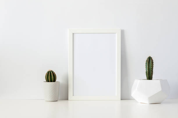 istock Two cactuses in pots against a white empty wall. Mockup frame. Geometric flower pot. 1309095983