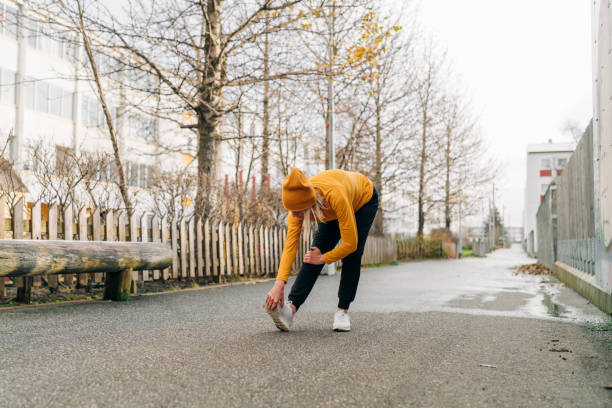istock Woman doing leg stretches on road outside 1309096503