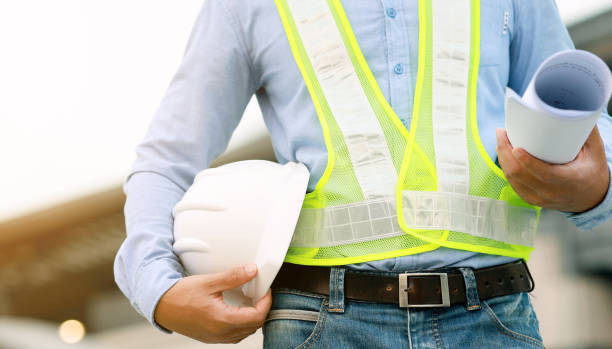 istock Male engineer wearing safety helmet looking at blueprint at construction site 1309096741