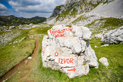 Rocks in the Durmitor mountains in Montenegro. Signpost on the stone at Bobotov kuk and izvor.
