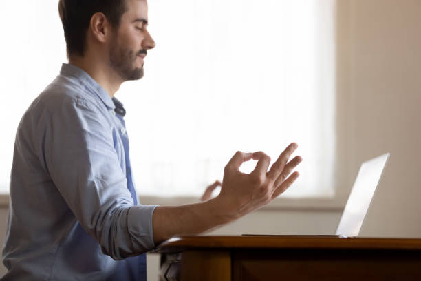 istock Calm millennial male remote worker relaxing at workplace practicing yoga 1309100963