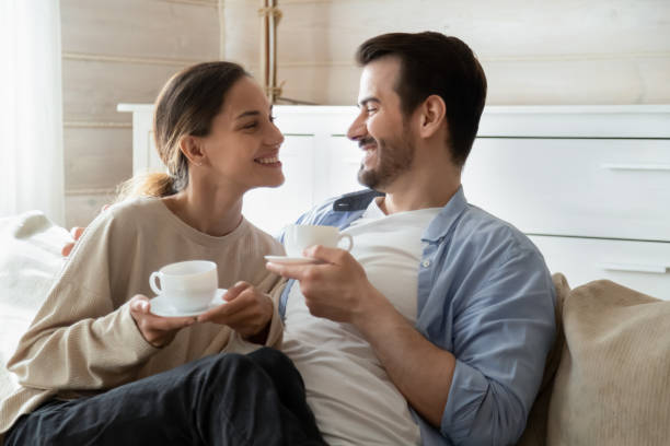 istock Happy married couple drinking tea enjoy being at home together 1309100989