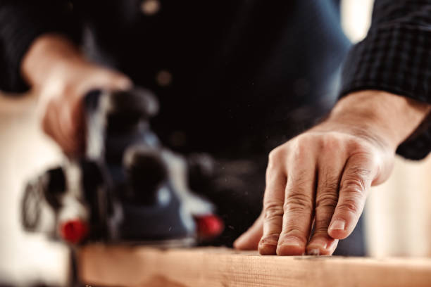 istock Carpenter's hands working with electric planer in a workshop 1309103458