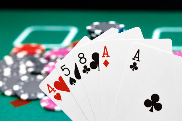 istock Playing cards and chips on green casino table background 1309103737