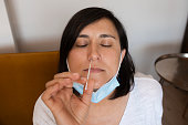 Corona virus self-test for home, woman makes a quick test by a swab in the nose.