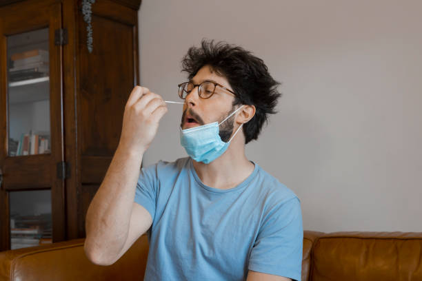 Young man auto checking Coronavirus infection with Antigen kit at home.