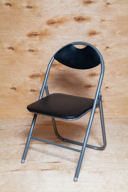 istock Folding chair stands on wooden background 1309105544