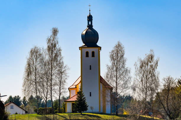 A small church among the trees on the hill.