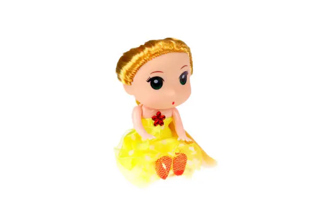 Photo of A doll in a yellow dress. On a white background, isolated.