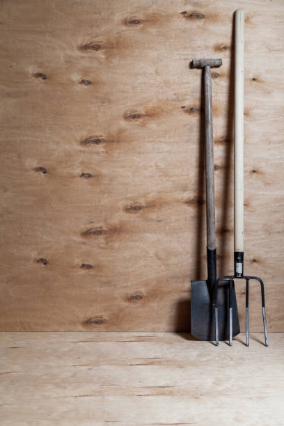 istock Fork on wooden handle and shovel stand on wooden background 1309105934
